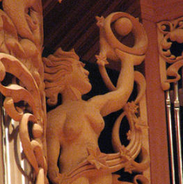 Woman with orb, carved wood sculpture in pipe shade carvings of Pacific Lutheran University, Tacoma, WA, wood sculptor Jude Fritts