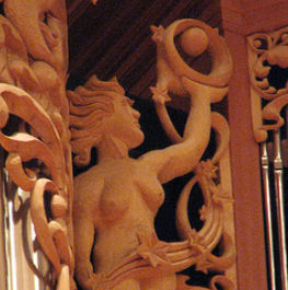 Woman with orb, carved wood sculpture in pipe shade carvings of Pacific Lutheran University, Tacoma, WA, wood sculptor Jude Fritts